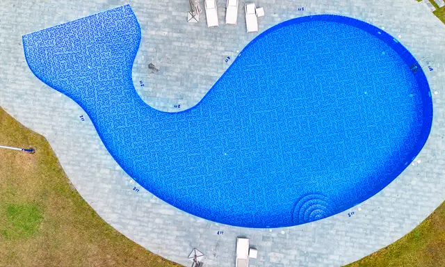 A Poolside Area with a Clear Swimming pool, Surrounding Deck Space, and Seating for Relaxation